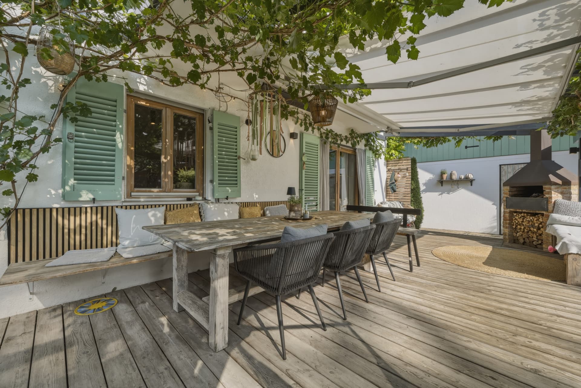 Terrasse mit Pergola und langem Holztisch